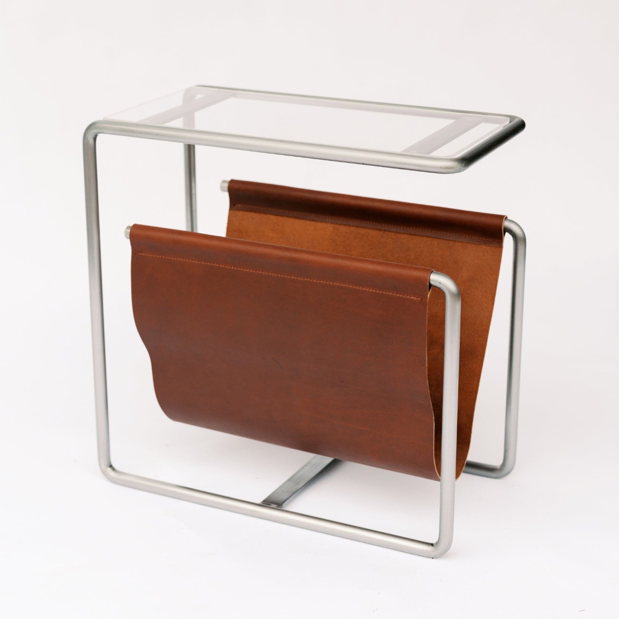 Raw cold rolled steel and reddish brown full-grain leather magazine rack side table with tempered glass top
