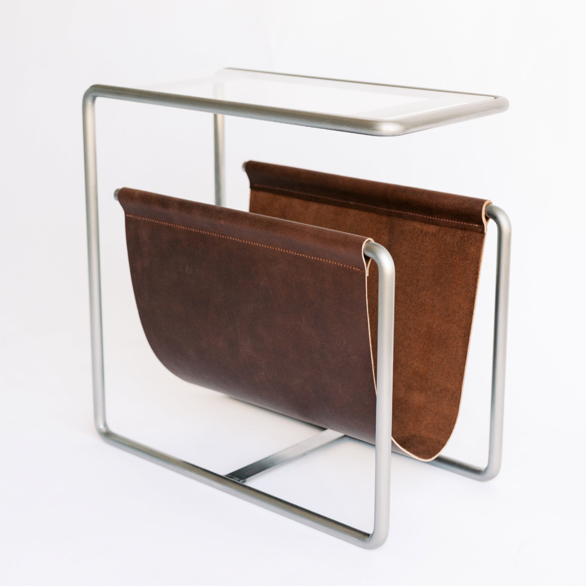 Raw cold rolled steel and chocolate brown full-grain leather magazine rack side table with tempered glass top