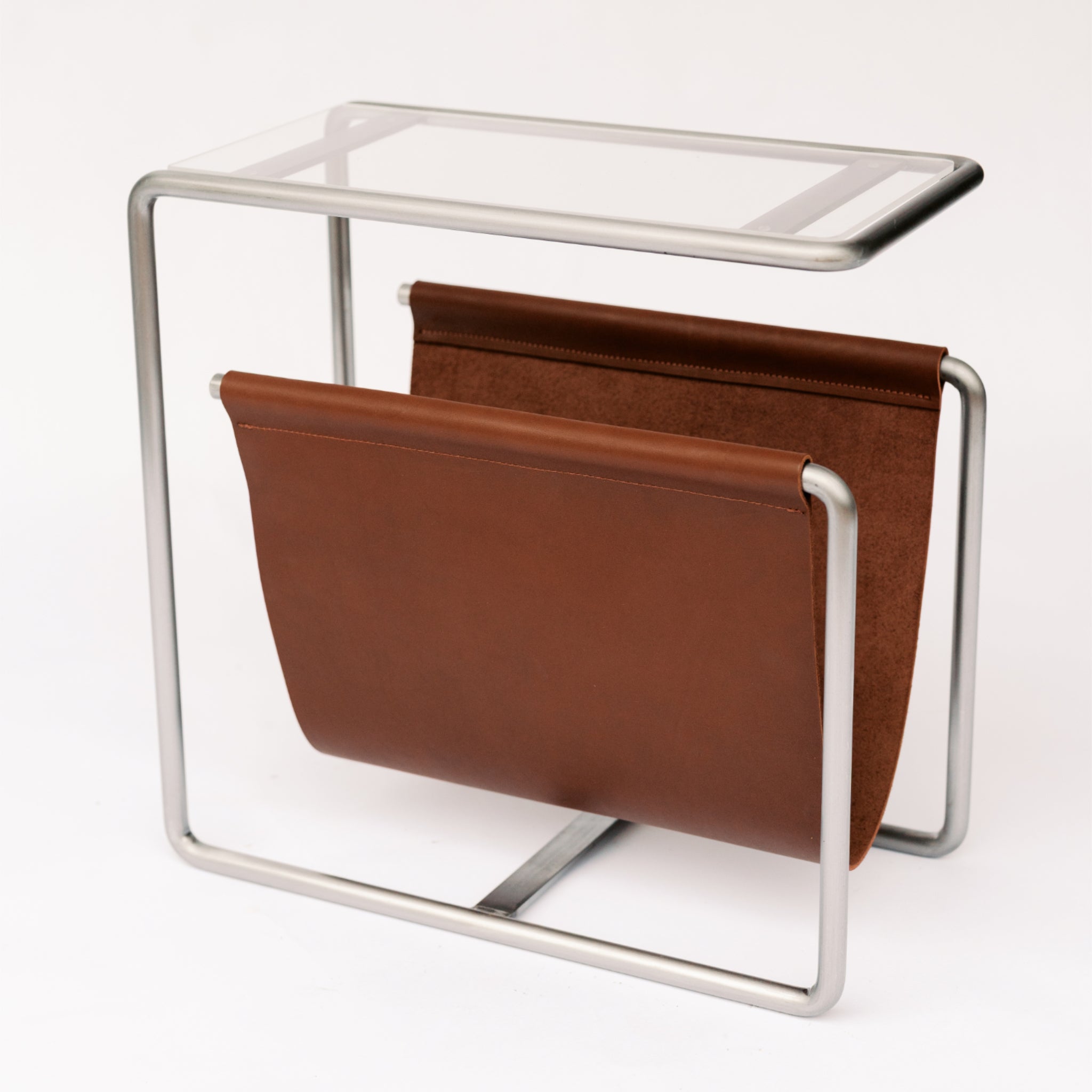 Raw cold rolled steel and medium brown full-grain leather magazine rack side table with tempered glass top