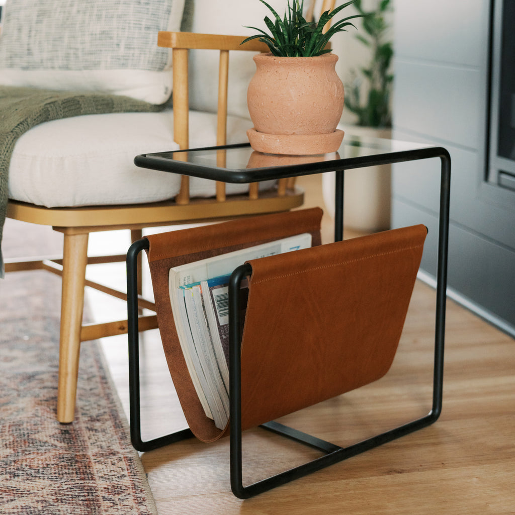 Black oxide steel and leather magazine rack side table with tempered glass top and full-grain leather sling